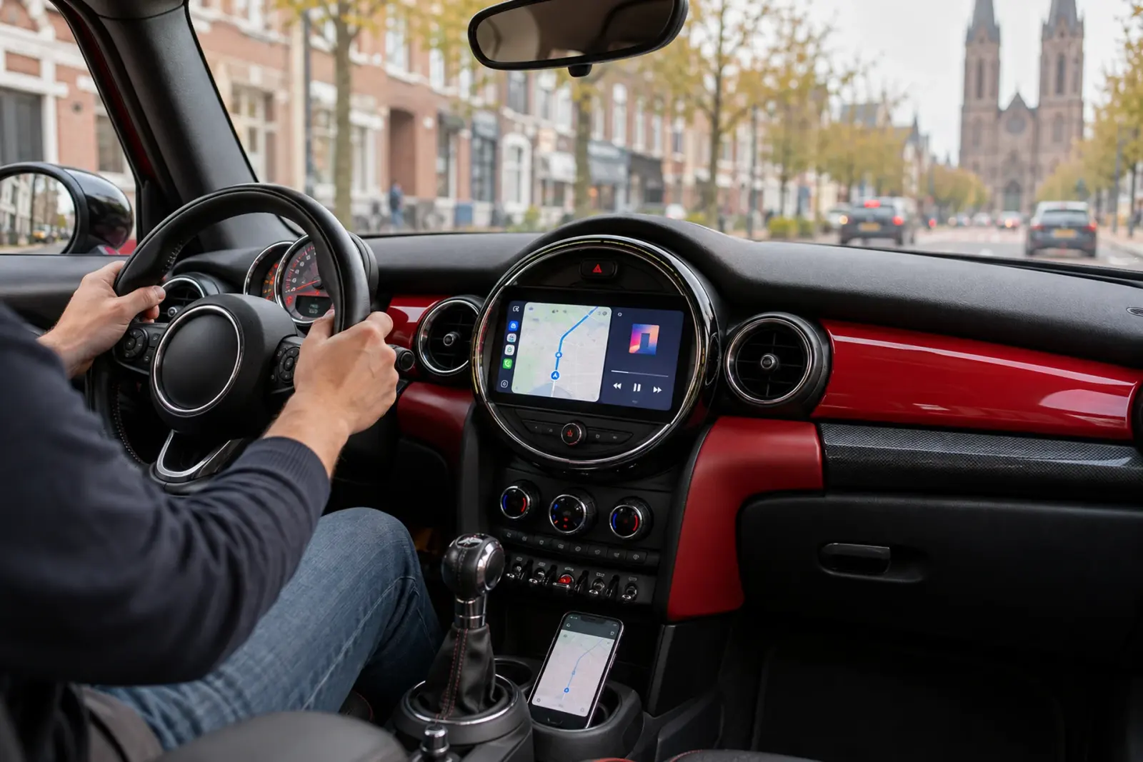 CarPlay bestellen in Tilburg: navigatie op het ronde CarPlay-scherm van een Mini in het centrum van Tilburg, met kerktorens op de achtergrond